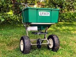 LESCO broadcast spreader on a green lawn
